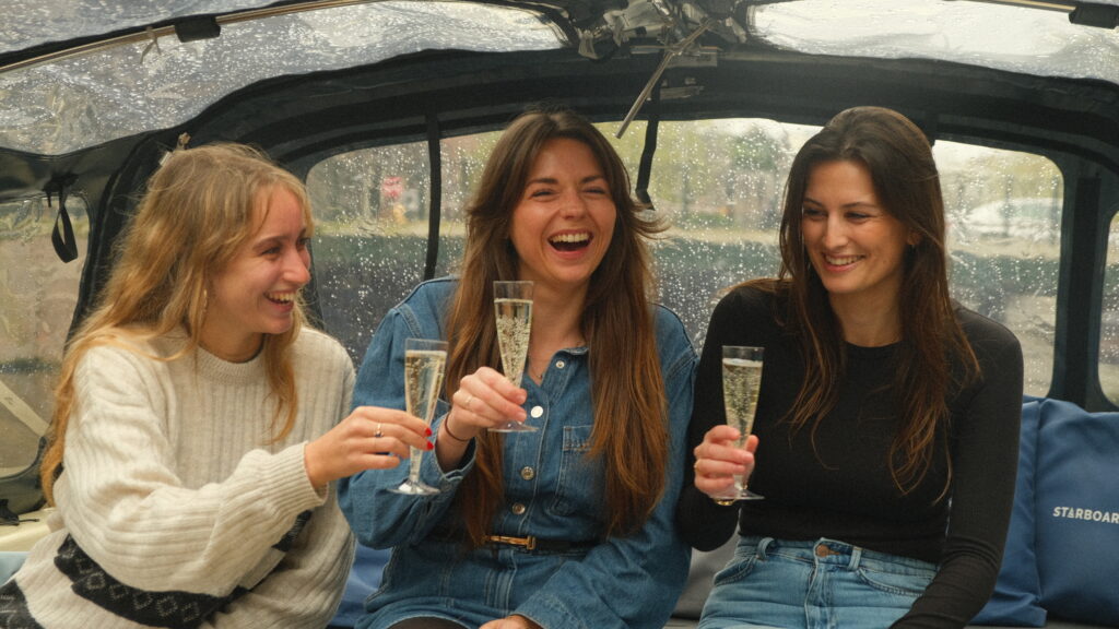 3 meisjes die cava aan het drinken zijn tjidens een privé boottocht Amsterdam als één van de ideeën vrijgezellenfeest vrouwen.