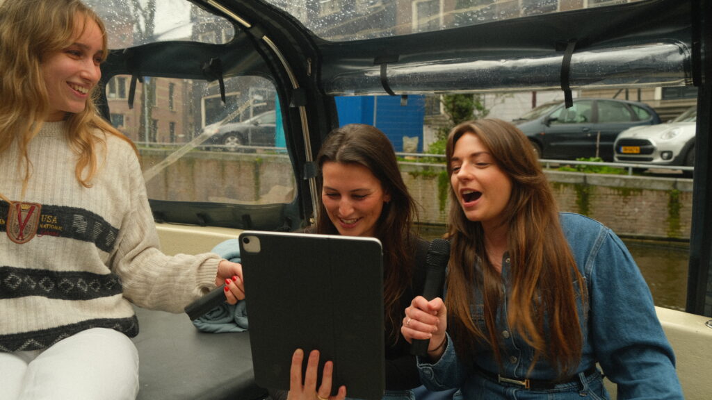 Meisjes aan het zingen in een microfoon op een Karaoke Boot Amsterdam