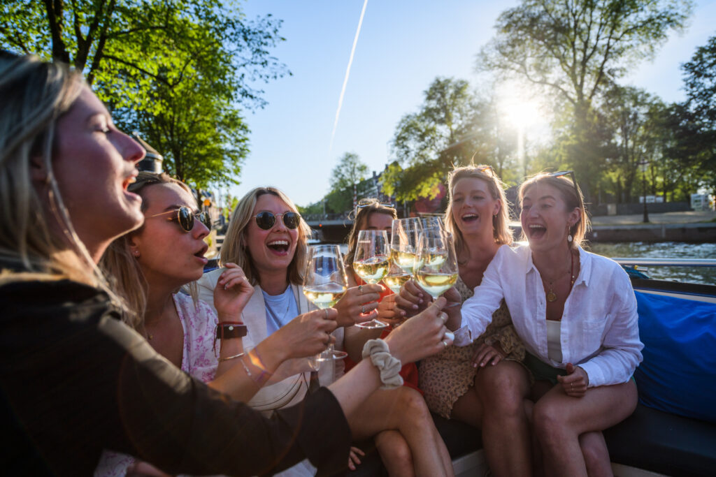 girls holding up wine glasses during hen party activities Amsterdam