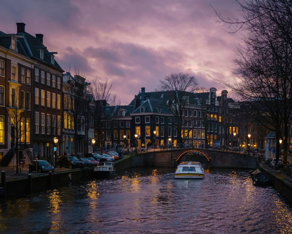Amsterdam canals with a purple hue in the sky.