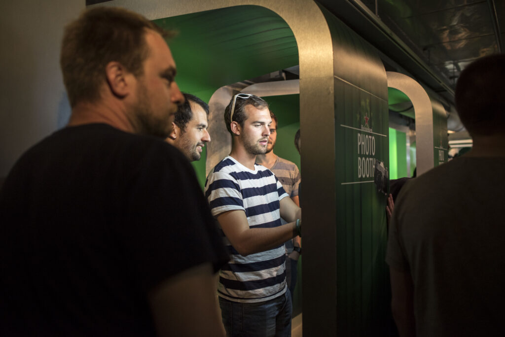 A group of men standing in the Heineken Experience.